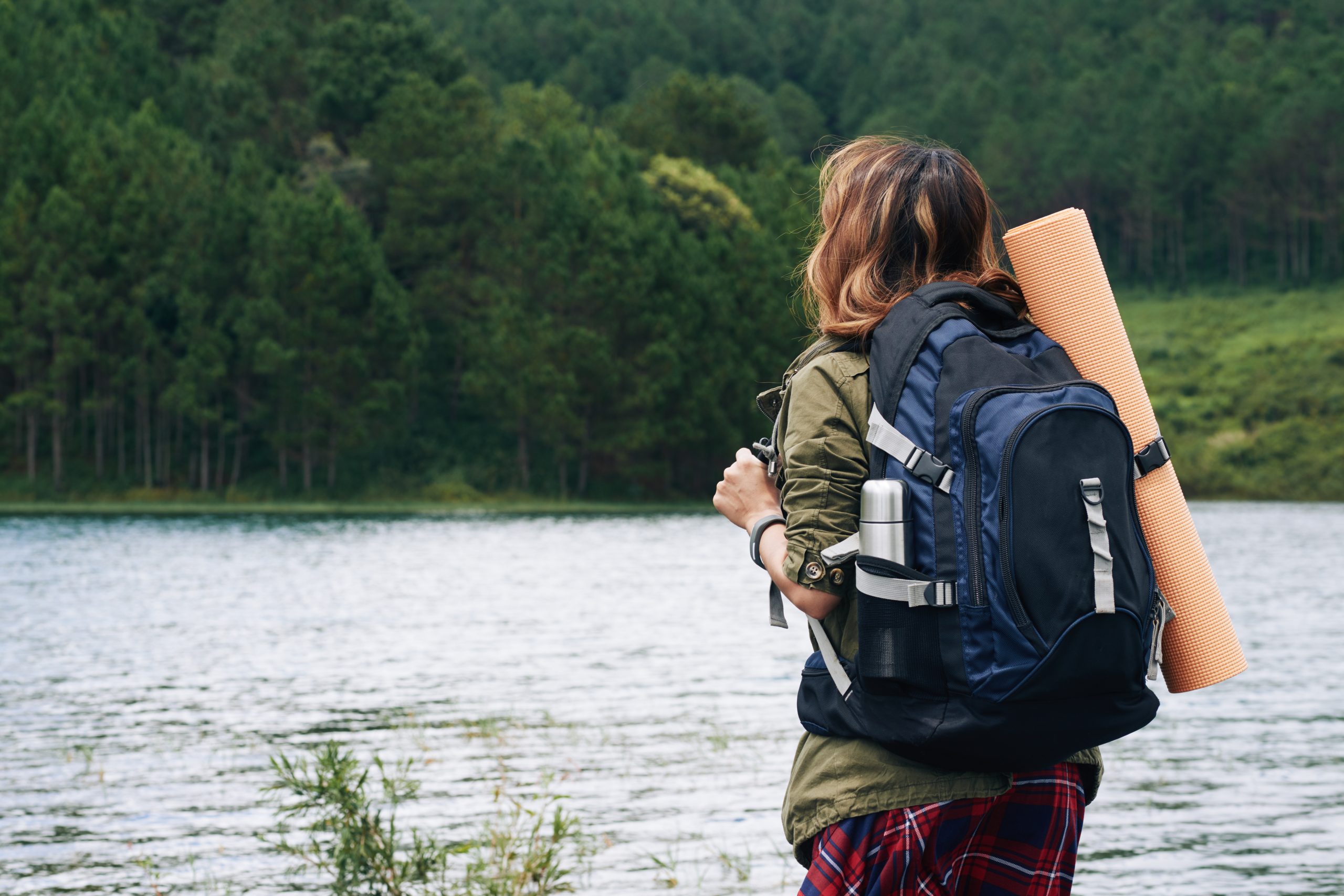 A hiker looking out over a still lake — the reflective posture of professional mentoring