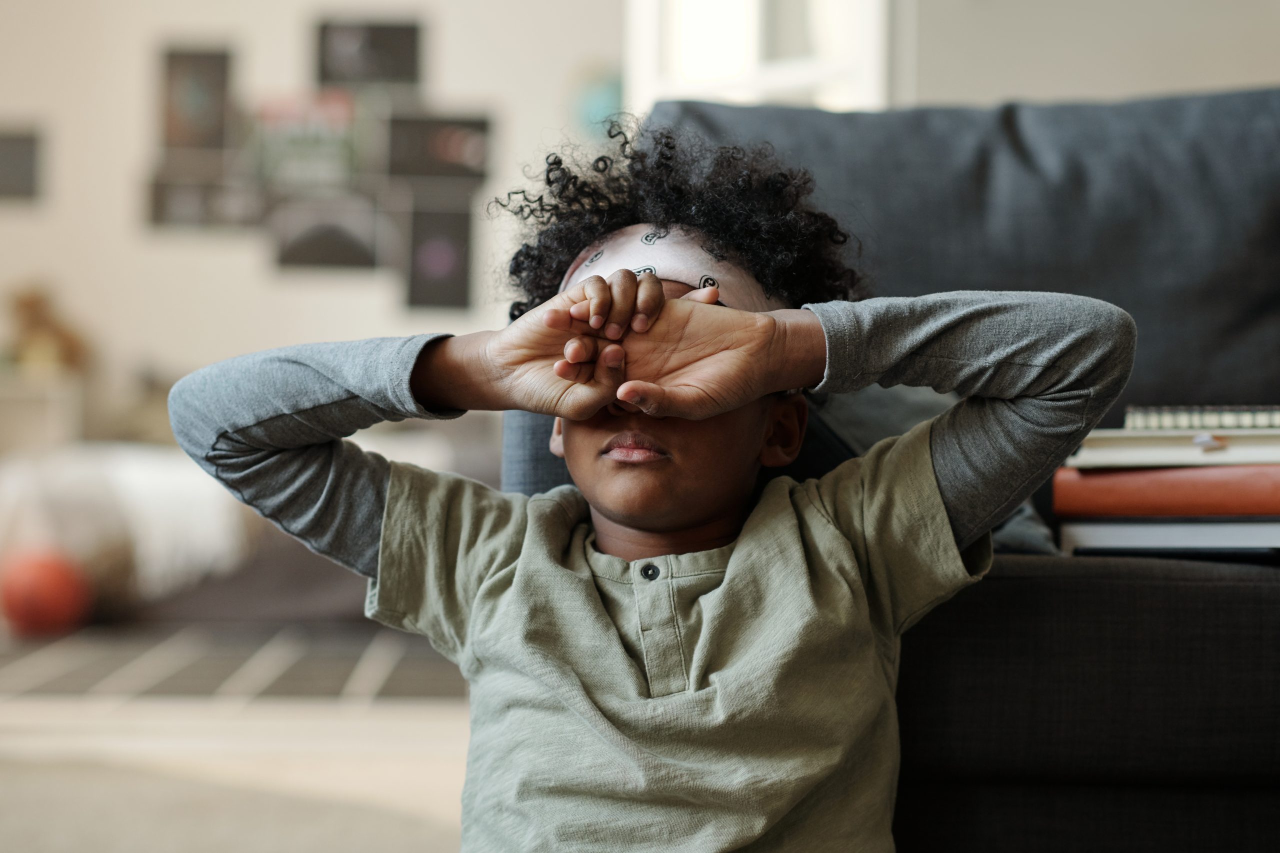 Accountability — a young person seated on the floor and hands across their face hiding themselves