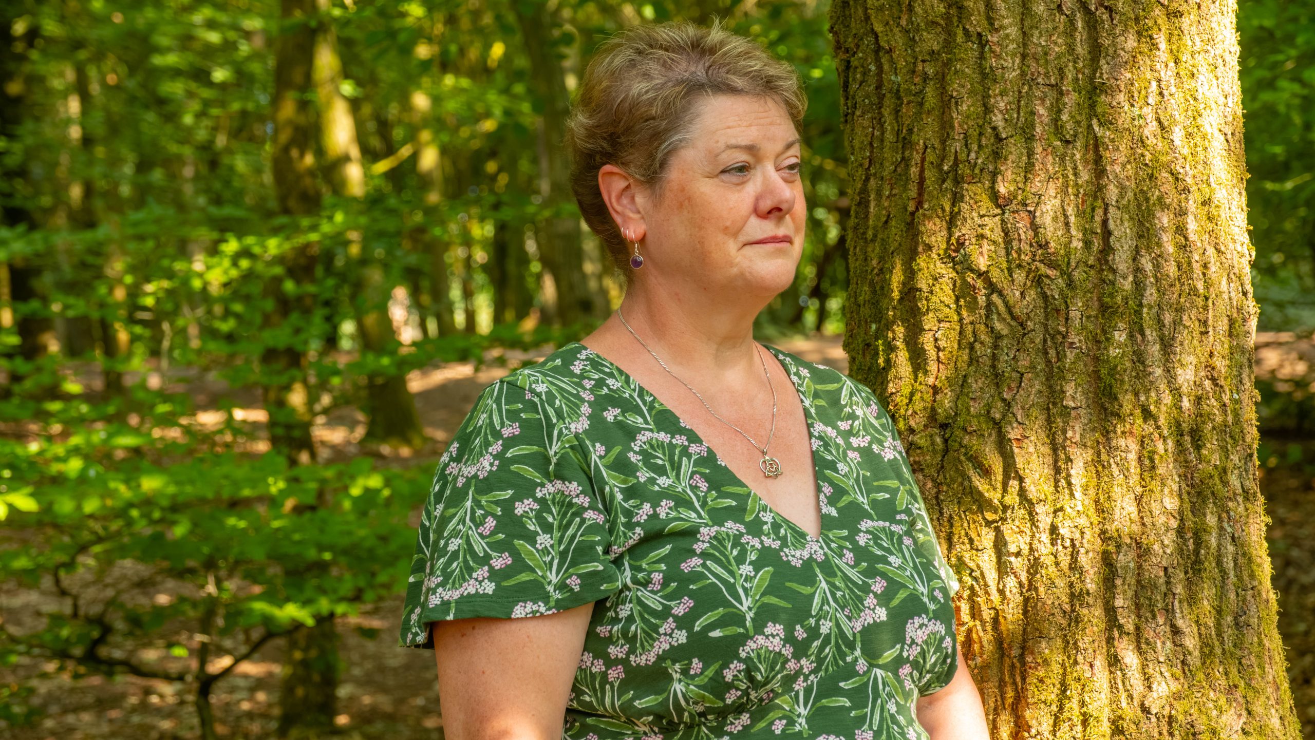 Annie in the woodland leaning against a tree taking time out in the sunlight